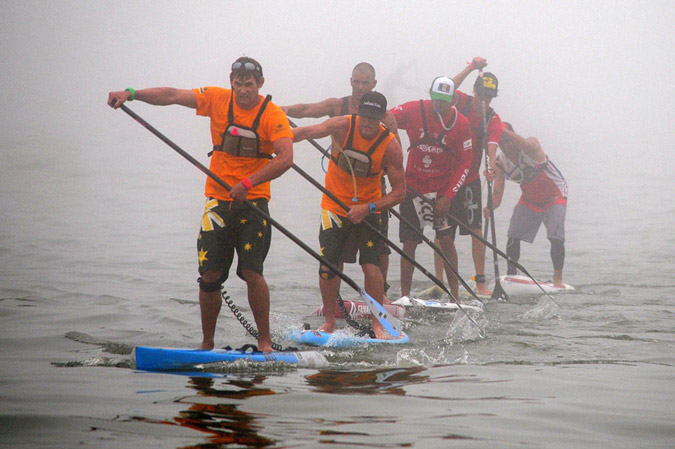 Australia’s Jaime Mitchell led the pack during the foggy SUP Long Distance Race and won the Gold Medal in a dramatic and tense finish. Trailing Mitchell, from front to back are Kelly Margetts (AUS), Paul Jackson (NZL), Fernando Stalla (MEX) and Casper Steinfath (DEN). Photo: ISA/Tweddle